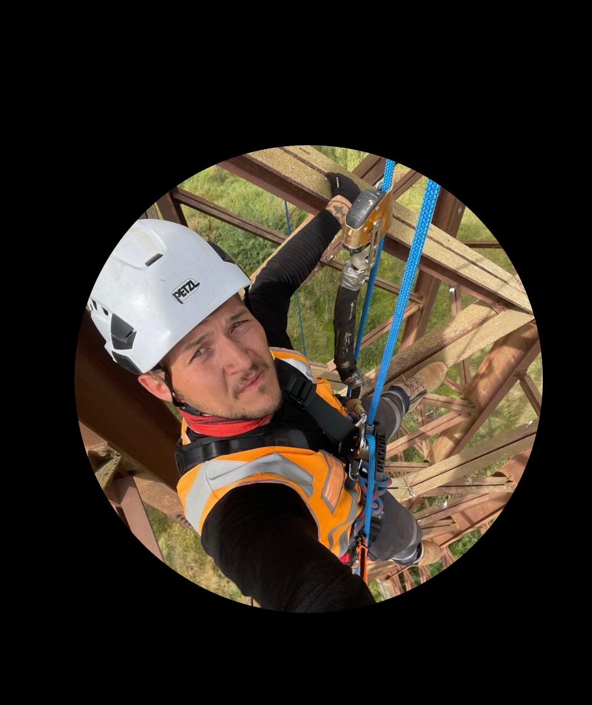 Kaan Karabina performing a rope-access structural inspection while suspended on a steel bridge truss